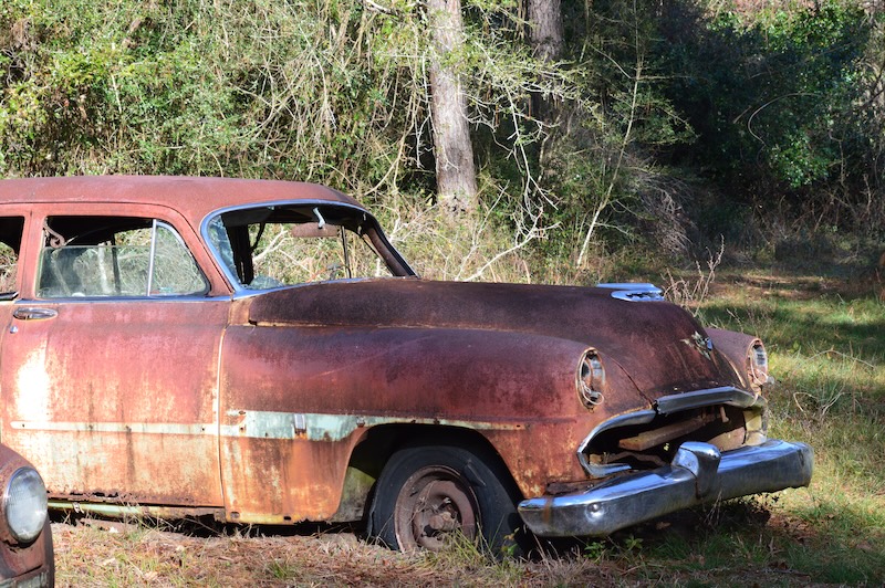 Skrotbil med rost utomhus
